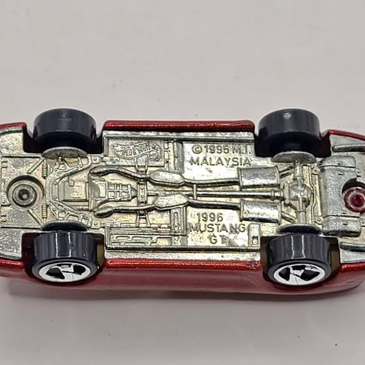 1/64 scale diecast car model with engine-detail panel and model text on silver body