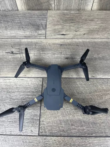 Quadcopter drone with four propellers and gray body, compact foldable arms