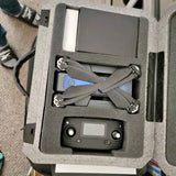 Gray quadcopter drone with four propellers and controller in foam case