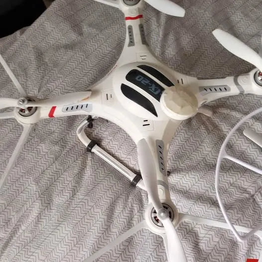 White quadcopter drone with visible propellers and front control panel