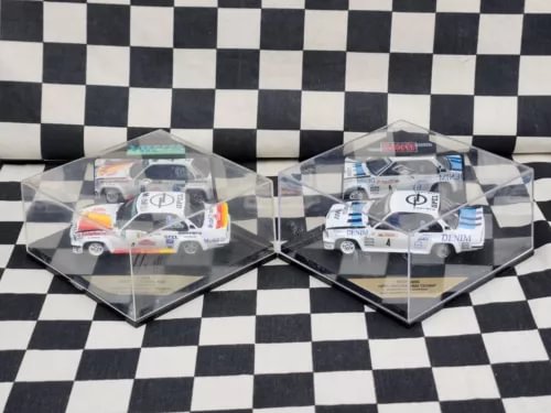 Two 1:43 rally diecast model cars in clear display boxes, white with orange and blue.