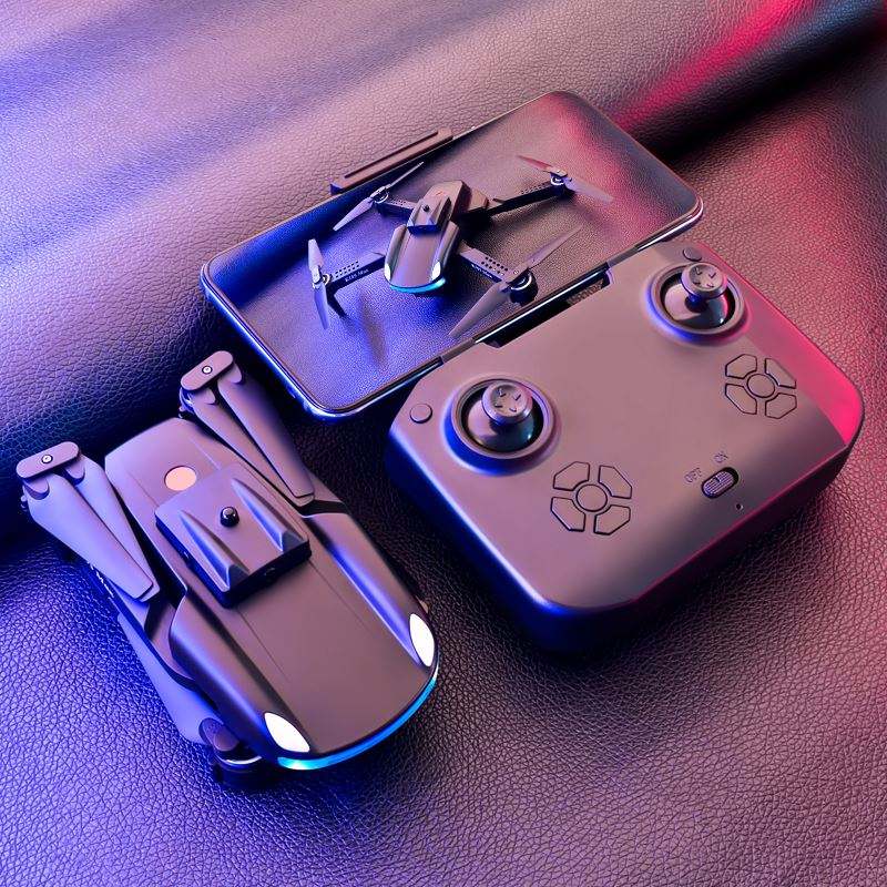 Small quadcopter drone with front lights, viewed from above on a surface