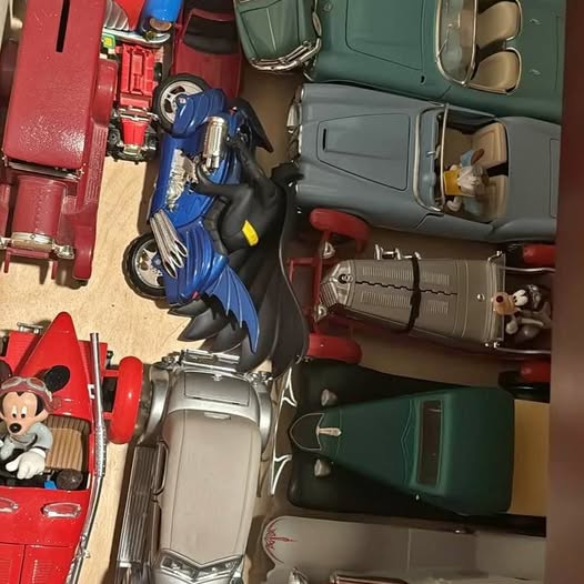Diecast car collection with red, blue, green and white vehicles on display