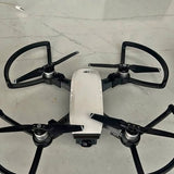 Quadcopter drone with four propellers and front camera, folded arms visible