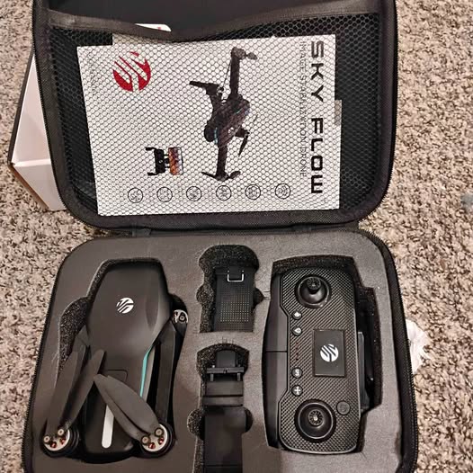 Black drone accessories set in open case: controller, drone body, landing gear, strap