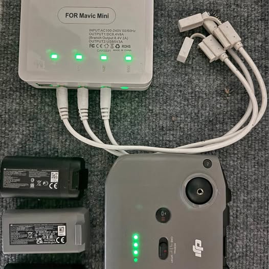 Drone battery charger with LED indicators, cables, and two battery packs