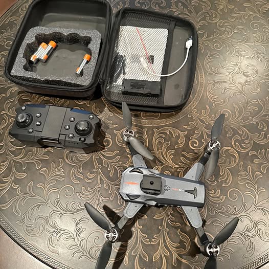 Gray quadcopter drone with remote controller and open hard case