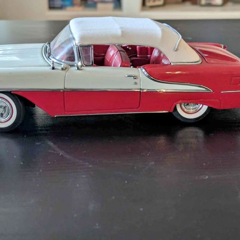 1:24 diecast model car, red body with cream convertible top and chrome trim