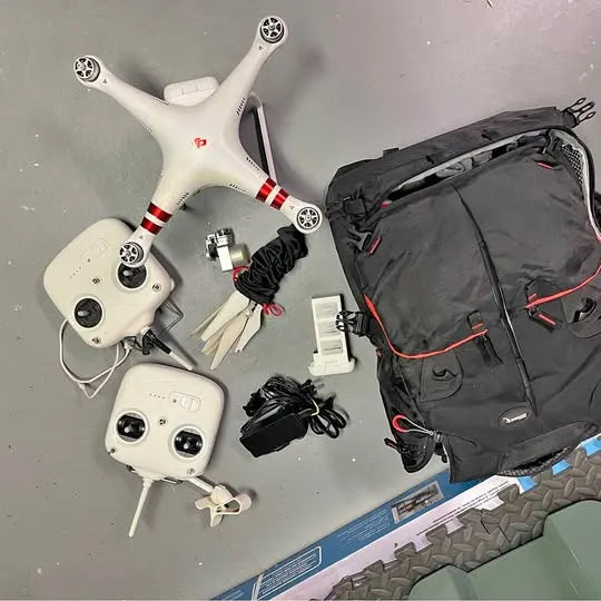 DJI Phantom drone with white quadcopter, controller, cables, and black carry bag
