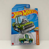 Green diecast toy truck on Hot Wheels blister card, '83 Chevy Silverado