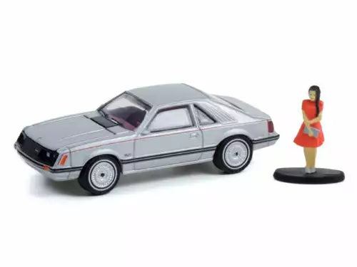 Silver coupe diecast model car with woman figure on round base