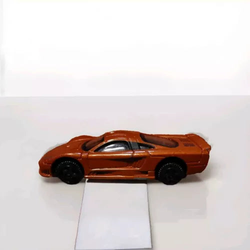 Burnt orange 1:64 diecast model car with black wheels and silver details