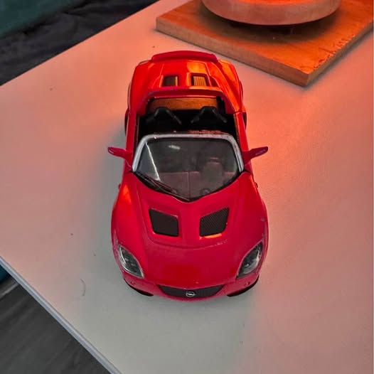 Red diecast sports car, front view with black grille and headlights