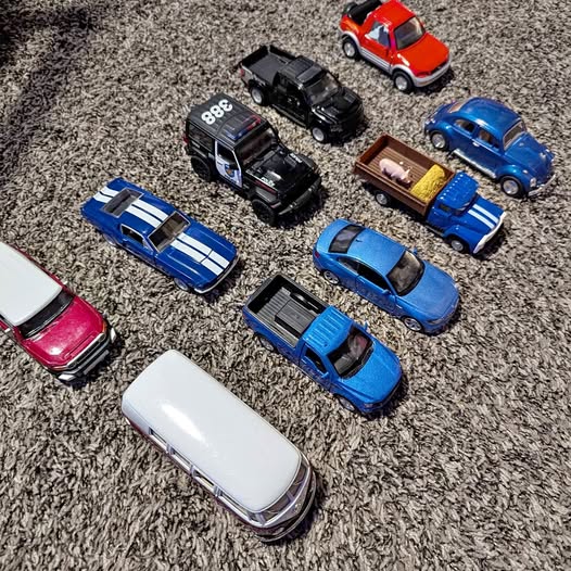 Diecast toy vehicles assortment with red, blue, white, and black cars