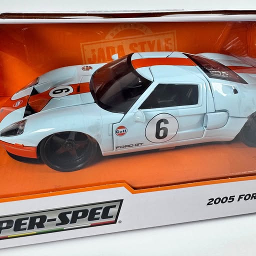 Light blue diecast race car model with orange stripes and number 6 on door
