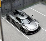 1:64 scale grey diecast sports car with black aero wing and front 3/4 view