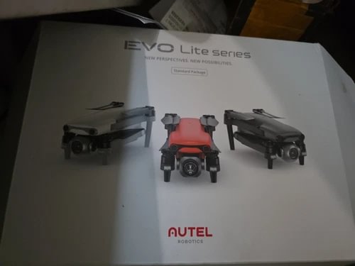 Orange quadcopter drone with landing legs, shown on product box