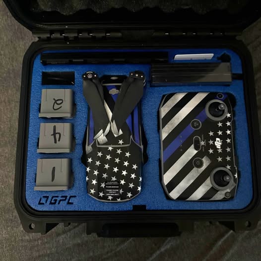 Folded drone in hard carrying case with blue foam inserts and patterned decals
