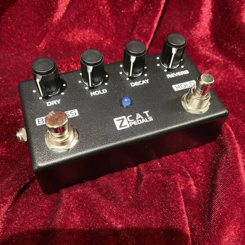 Compact ZCAT hold-reverb guitar pedal with footswitch, knobs, and LED indicator