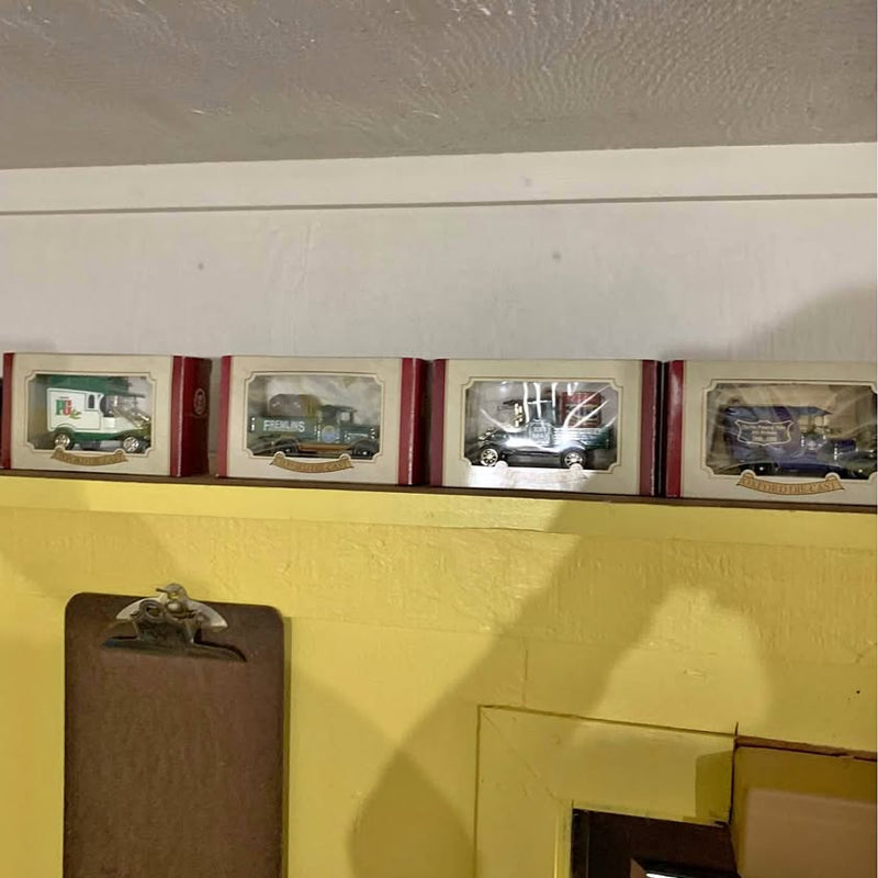 Diecast toy trucks in display boxes, four-count set with multicolor vehicles