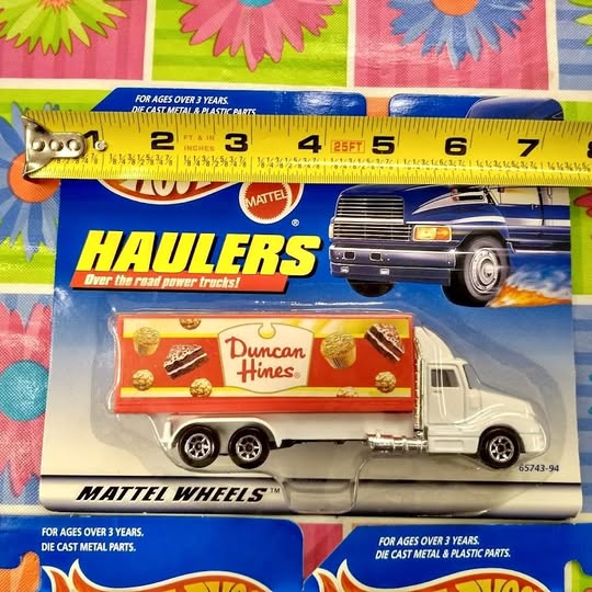 Diecast hauler toy truck in retail package, white cab with red trailer