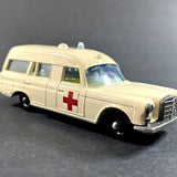Cream diecast ambulance van with red cross on side, detailed grille and windows.
