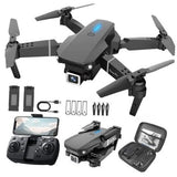 Foldable mini black drone with camera and four propellers; includes remote and spare parts