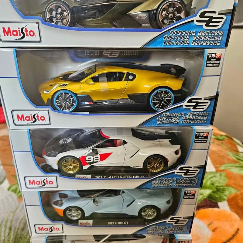 1:18 diecast model car in box, showing three sport cars: yellow, white, and dark green.