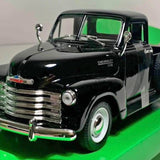 Black diecast metal pickup truck with chrome grille and Chevrolet front emblem, front view