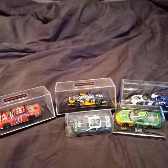 Autographed diecast race car in clear display box, numbered graphics, multi-pack view