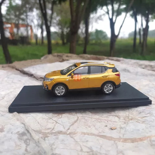 Diecast model SUV car in orange/yellow on black display base, side view