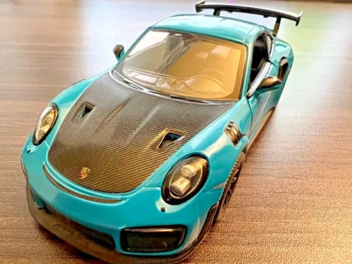 Teal sports car diecast toy with black hood vents and front headlights
