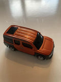 Orange diecast SUV with black windows and grille detail