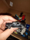 Black diecast pickup truck model with side view, held in hand, 1/64 scale.