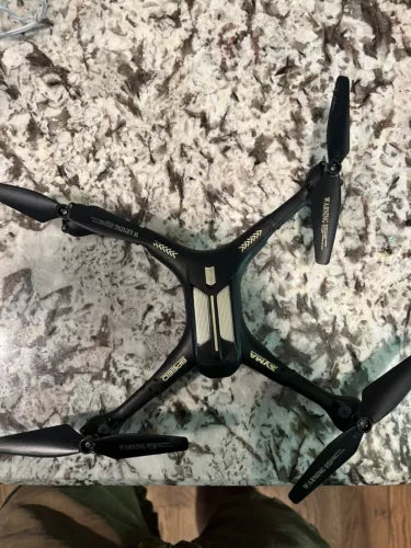 Black foldable quadcopter drone with front camera and four propellers