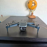 Gray quadcopter drone with blue arms and front camera module