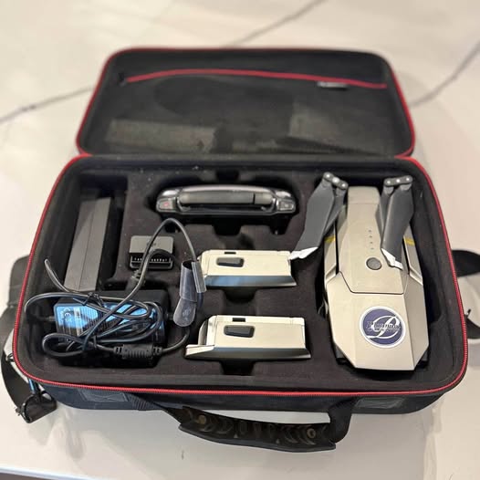Foldable drone in hard case with remote controller, cables, and spare parts