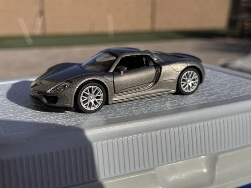 Gray and black diecast sports car toy with open cockpit and silver wheels
