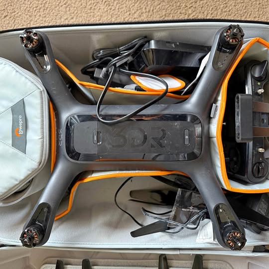 3DR Solo drone in open carrying case with orange trim and visible cables