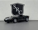 Black diecast sports model car with hood stripes, front three-quarter view, detailed wheels