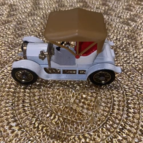 Vintage diecast model coupe car with light blue body, brown roof, black wheels