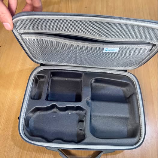 Drone carry case with foam inserts, open lid and molded compartments inside