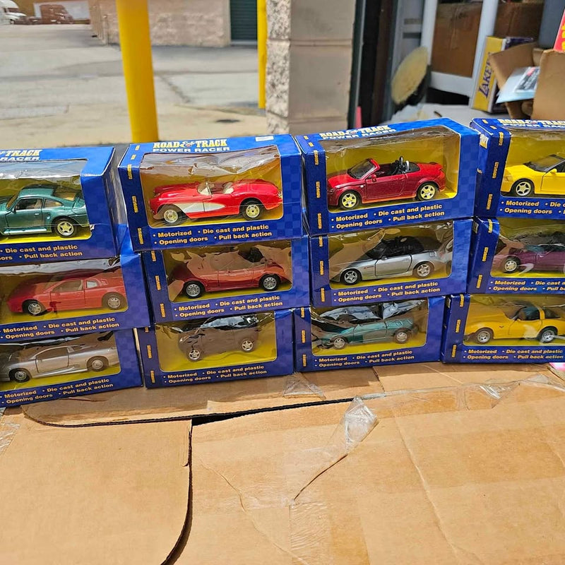 Diecast car lot with blue boxed cars, red and yellow models visible