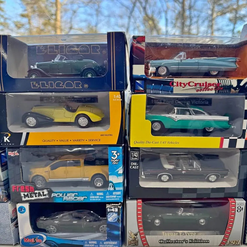 Assorted diecast cars and trucks in retail boxes, visible yellow, teal, and dark blue models