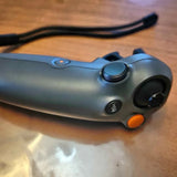 Blue-gray drone controller with thumb wheel and orange trigger