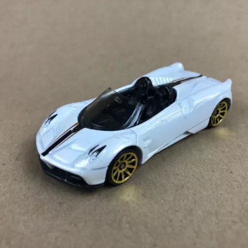 White roadster diecast car with black hood, open cockpit, and gold wheels
