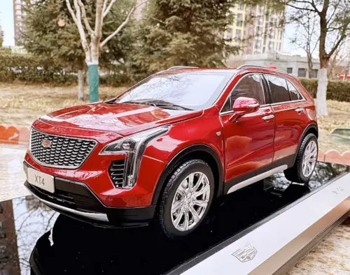 Red diecast SUV model car with chrome grille and headlights, front 3/4 view
