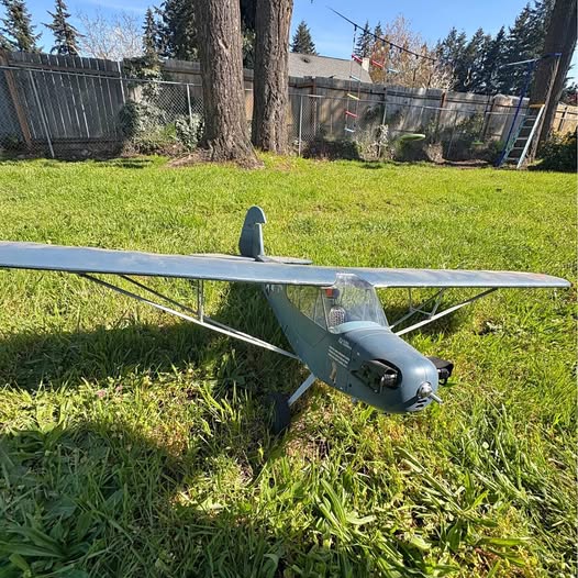 Gray RC airplane model with propeller and two wings