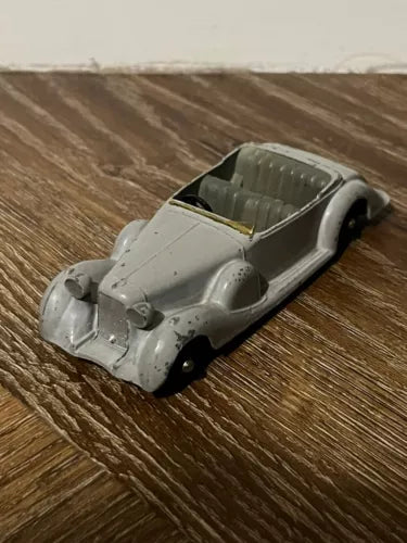 Gray diecast sports coupe model car with dark cockpit, front-left view