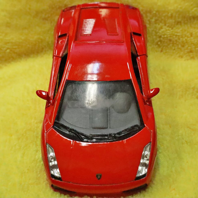 Red diecast sports race car front view with clear windshield and hood vents